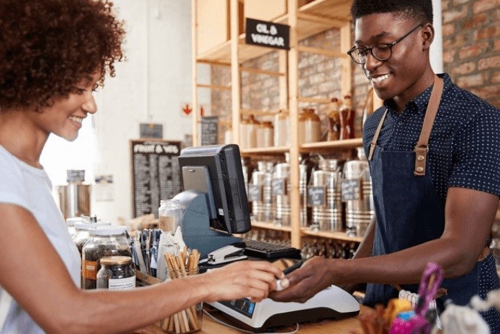 Woman using her Tehaleh loyalty card at the register for a discount on her purchases.