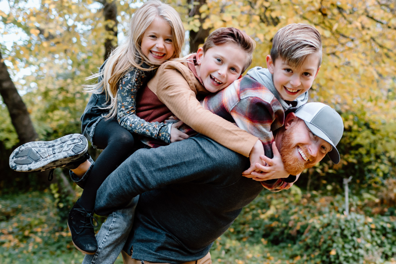 A man and his three kids pose for a family photo