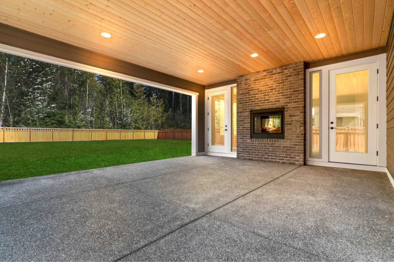 A spacious outdoor patio featuring a fireplace by Brookstone Homes