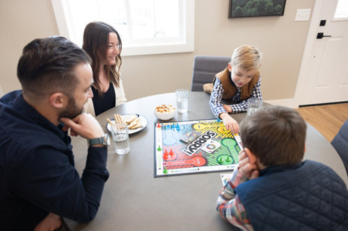 A family sitting at a table playing a popular board game