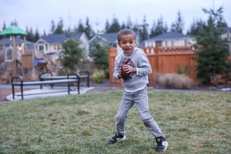 A young boy preparing to throw a football at a Tehaleh park.