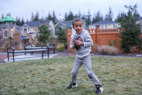 A young boy preparing to throw a football at a Tehaleh park.